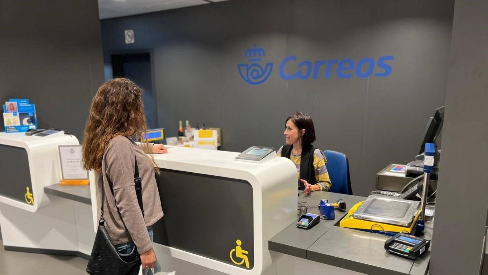 Una mujer es atendida en la oficina de Correos Sur.