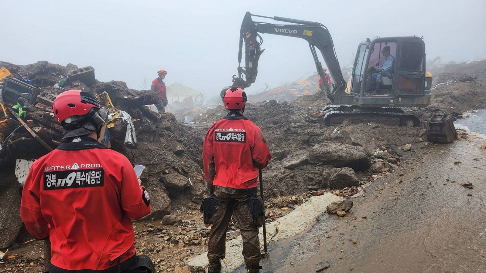 Equipos de rescate buscando personas desaparecidas tras un deslizamiento de tierra por fuertes lluvias en Yecheon, Corea del Sur.