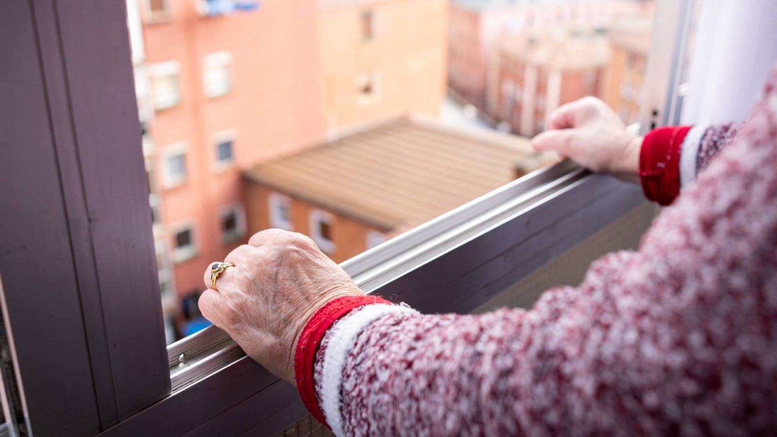 Una persona mayor mira por una ventana