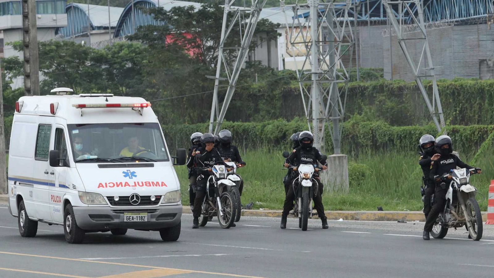 Una ambulancia junto a efectivos de la Policía transitan los exteriores de la Penitenciaría del Litoral, en Guayaquil (Ecuador).