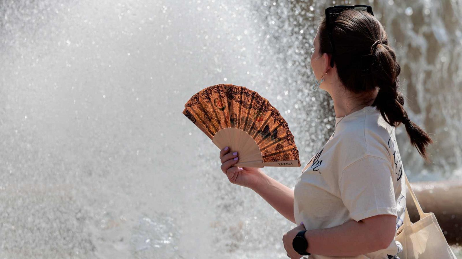 Una joven se abanica en la ciudad de Valencia ante las altas temperaturas