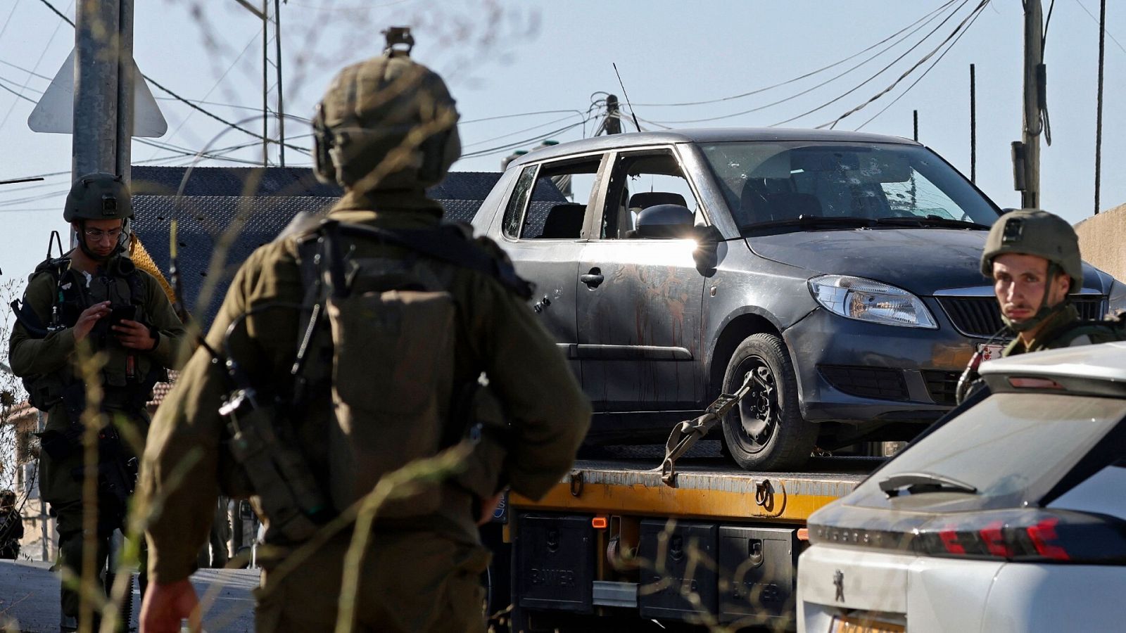 Las fuerzas de seguridad israelíes confiscan un vehículo de unos palestinos en el lugar de un tiroteo en Cisjordania