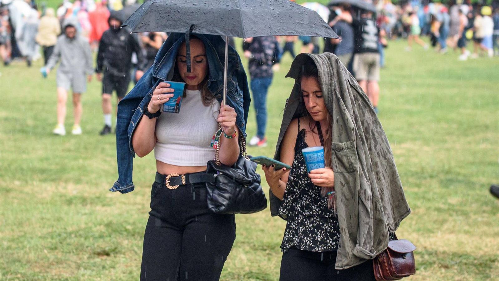 Dos personas se refugian de la lluvia en un festival de música