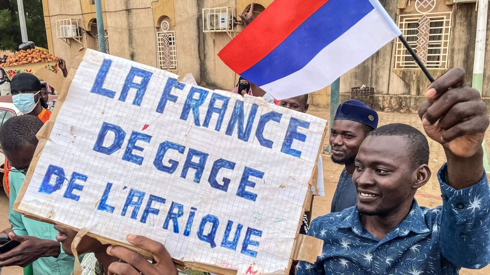 Manifestantes a favor de los golpistas en Niamey, Níger, con una bandera de Rusia y un carten en el que se lee: "Francia fuera de África". Foto: AFP