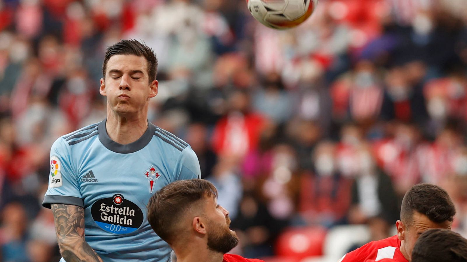 El jugador Santi Mina salta por el balón en un partido del Celta de Vigo contra el Athletic de Bilbao