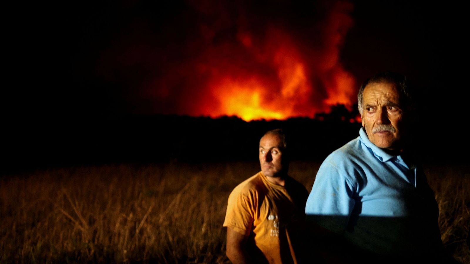 Dos personas observan un incendio forestal en Aljezur, Portugal