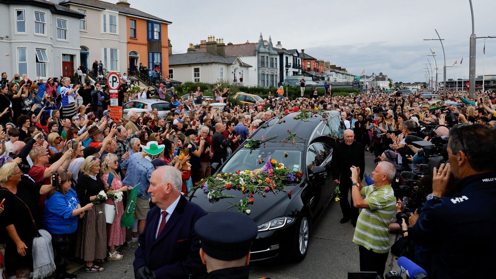 Los seguidores se agolpan en la calle mientras ven pasar el coche fúnebre de la cantante irlandesa