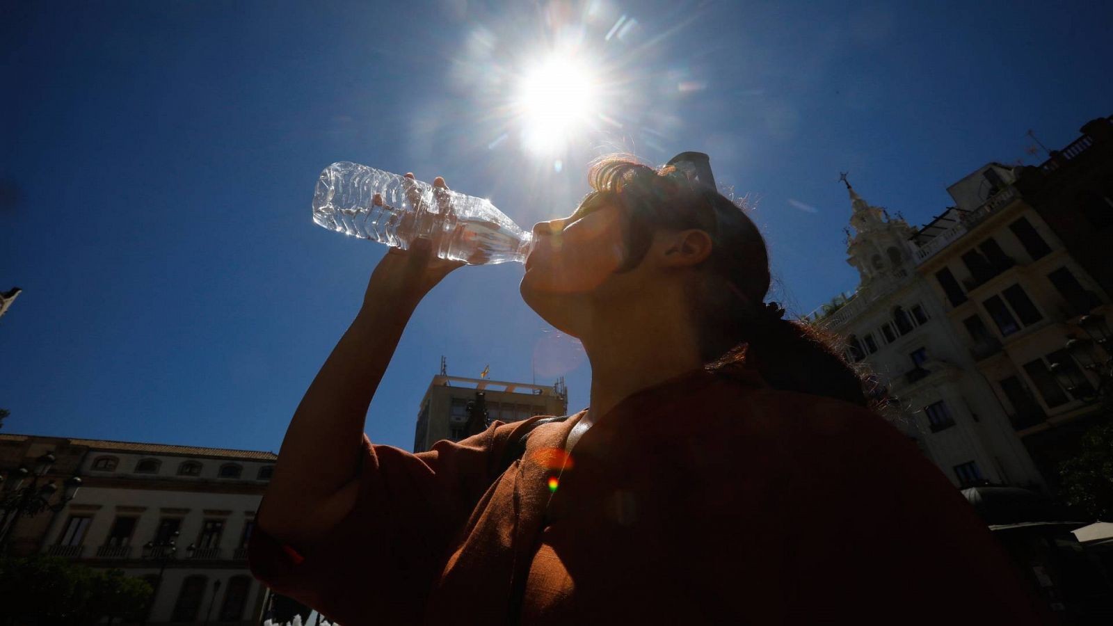 Una mujer se refresca bebiendo agua en el centro de Córdoba