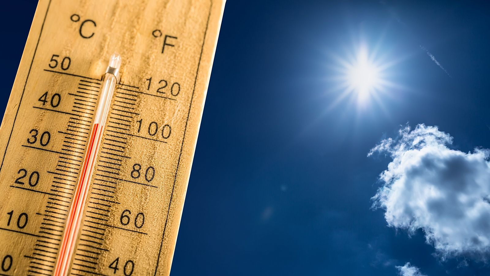 Un termómetro en un día de verano muestra la alta temperatura con el sol de fondo