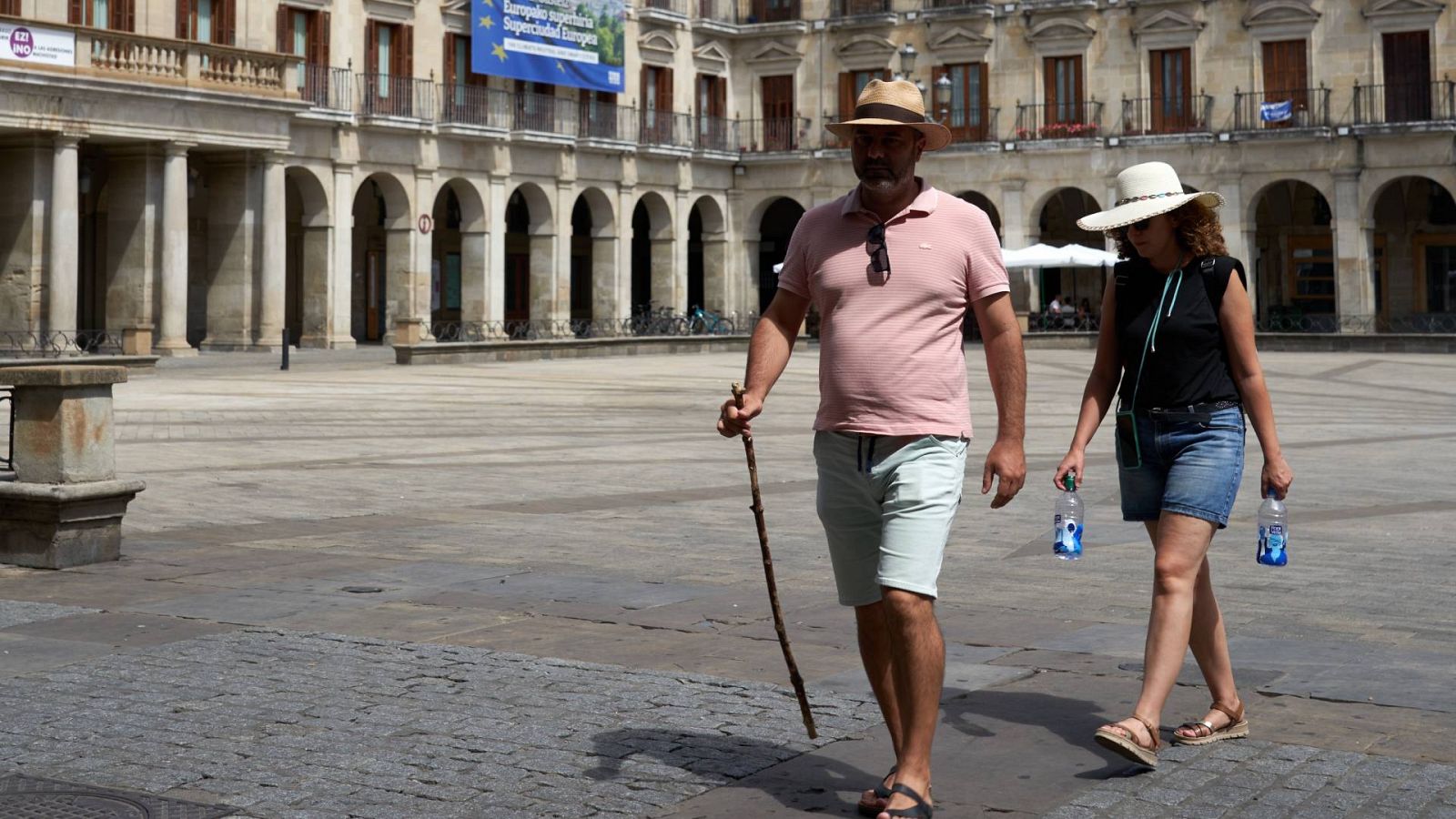 Turistas en la plaza de España de Vitoria protegiéndose de la cuarta ola de calor del verano.