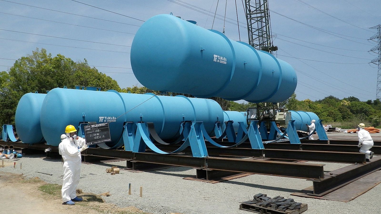 Trabajadores instalando grandes tanques para almacenar agua contaminada radiactiva en la planta de energía nuclear Fukushima Dai-ichi de TEPCO