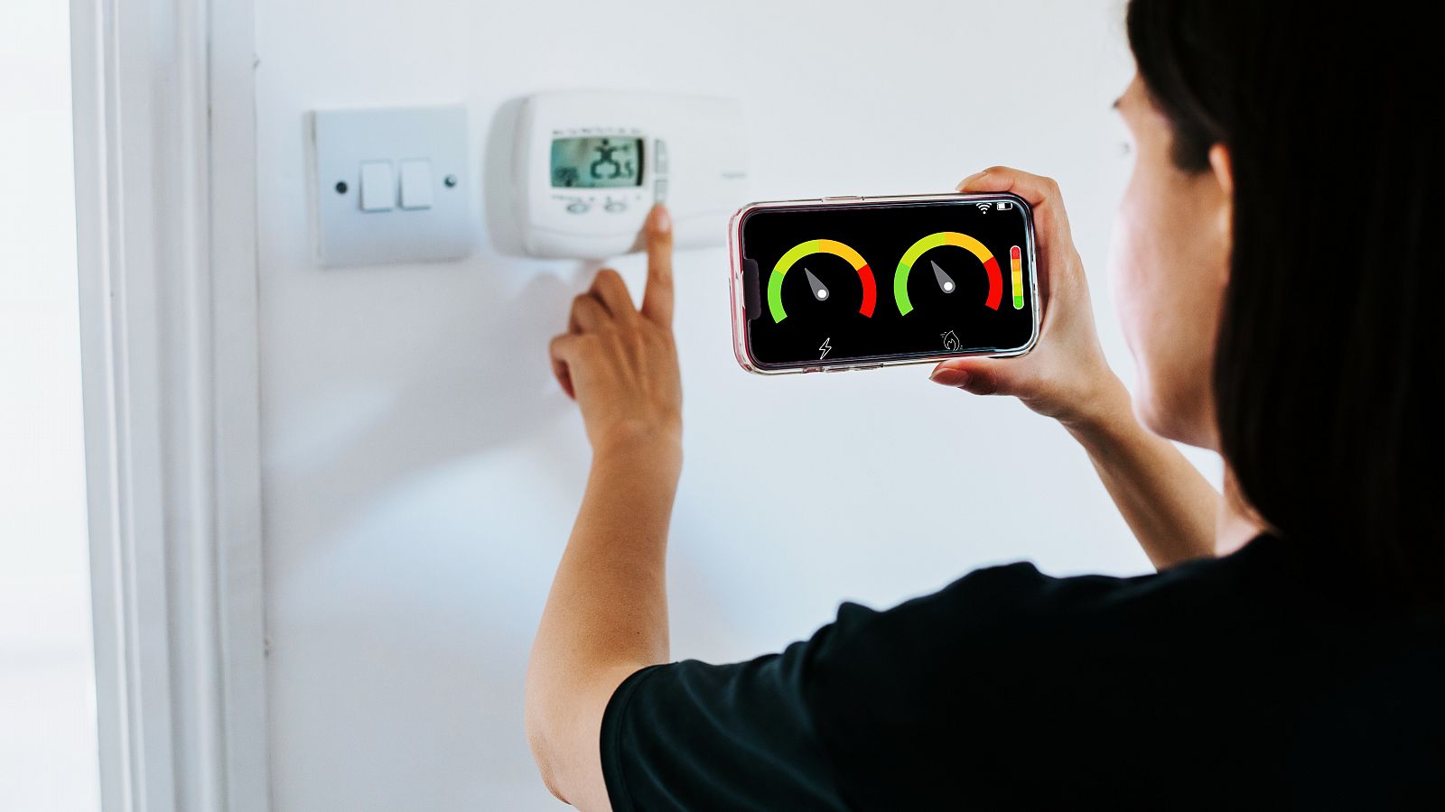 Close Up Of Woman Holding Smart Energy Meter In Living room Measuring Energy Efficiency