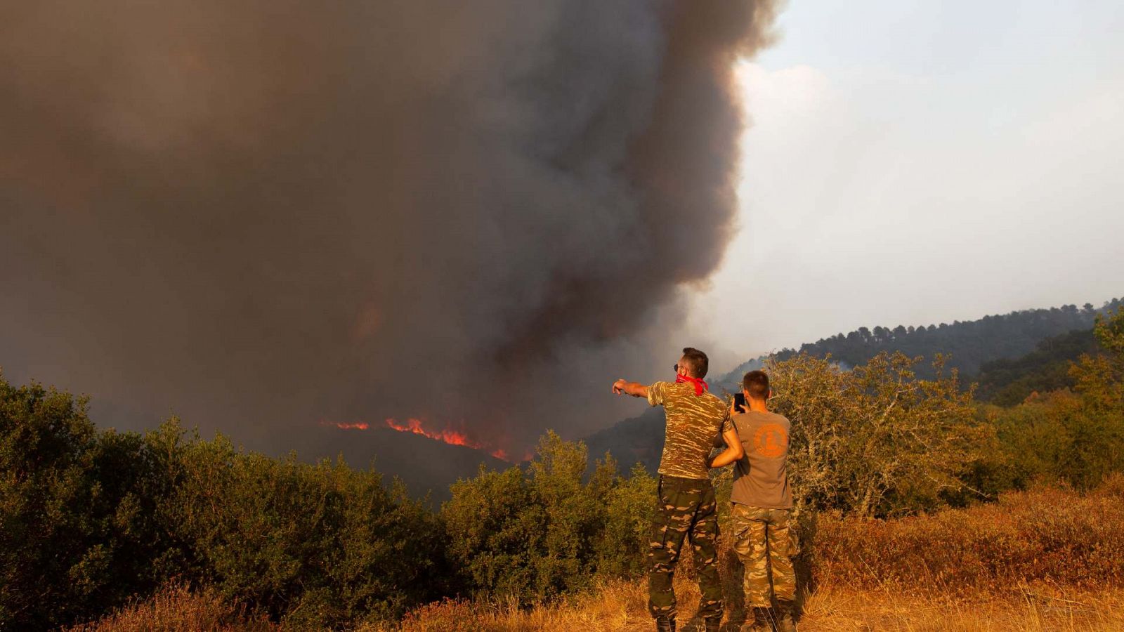 Unos residentes observan cómo el incendio se acerca a la aldea de Sikorrachis en Alexandroupolis, Tracia, al norte de Grecia