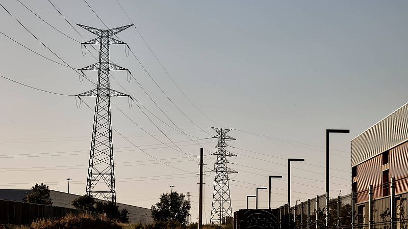 Torres de alta tensión bajo un cielo azul.