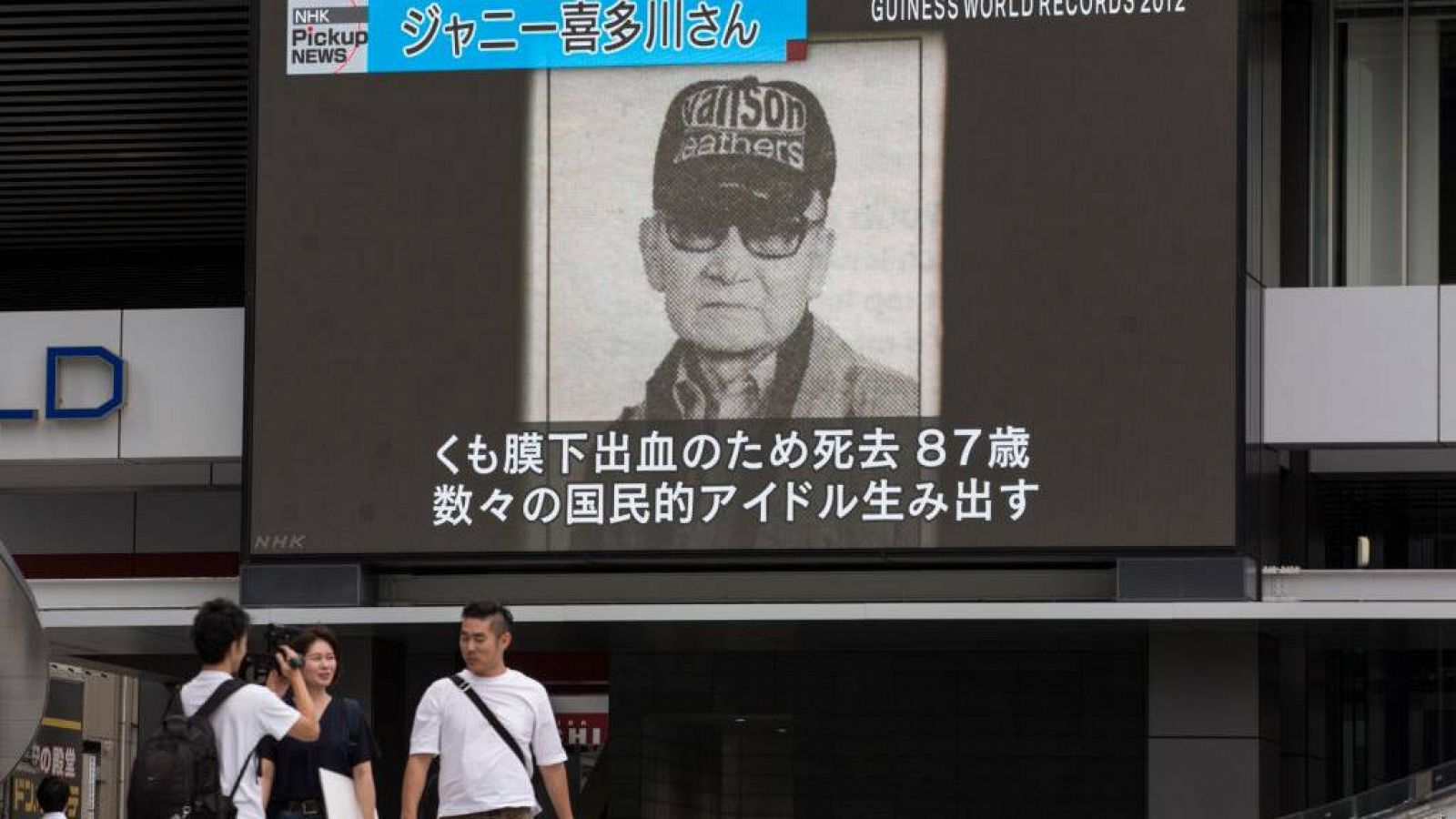 Peatones pasan junto a una pantalla grande que muestra imágenes de Johnny Kitagawa en un programa de noticias el 10 de julio de 2019 en Tokio, Japón.