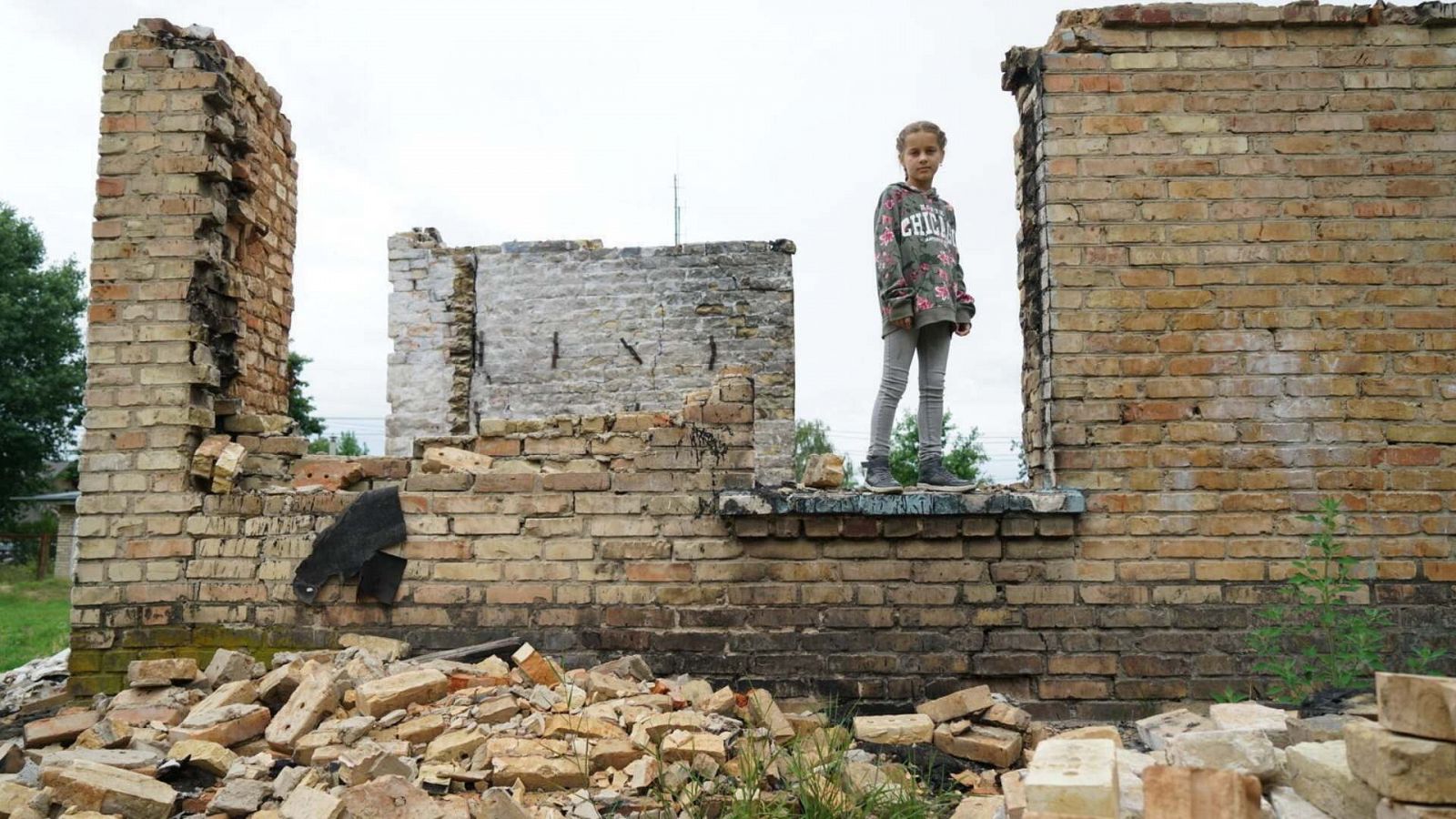 Una niña sobre los escombros de una escuela destruida en Horenka, Ucrania