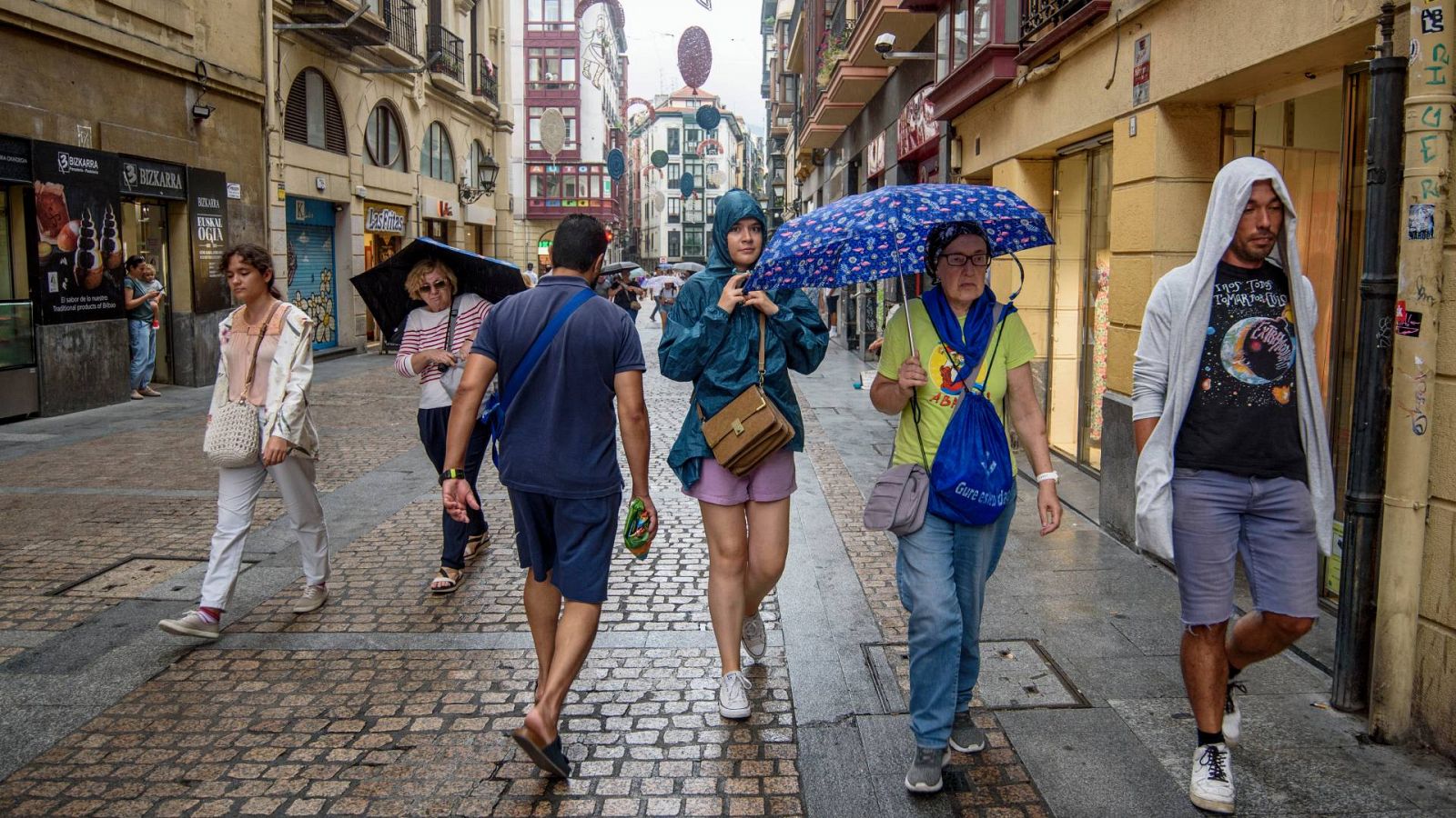 Tiempo: Viandantes se protegen de la lluvia en Bilbao en una imagen del pasado viernes