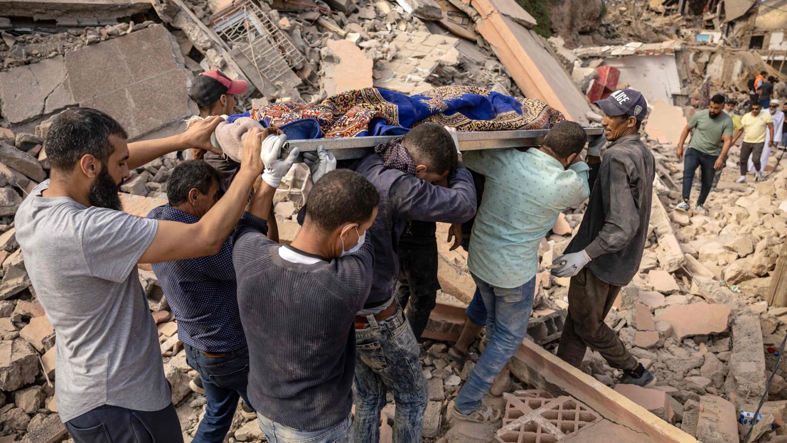 Varias personas llevan el cuerpo de una víctima del terremoto en Imi N'Tala, cerca de la ciudad de Amizmiz