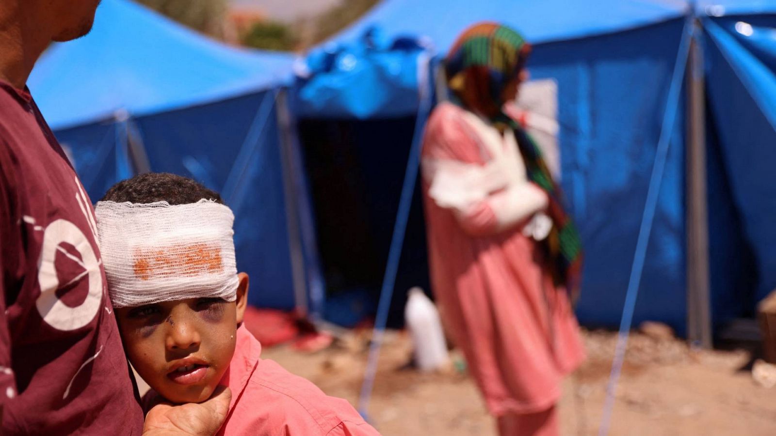 Ylias, de 13 años, uno de los heridos en el terremoto de Marruecos, es confortado por su padre en Talat N'Yaaqoub.