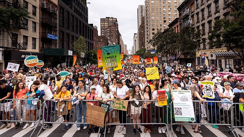 Los manifestantes enseñan carteles mientras participan en la marcha para acabar con los combustibles fósiles