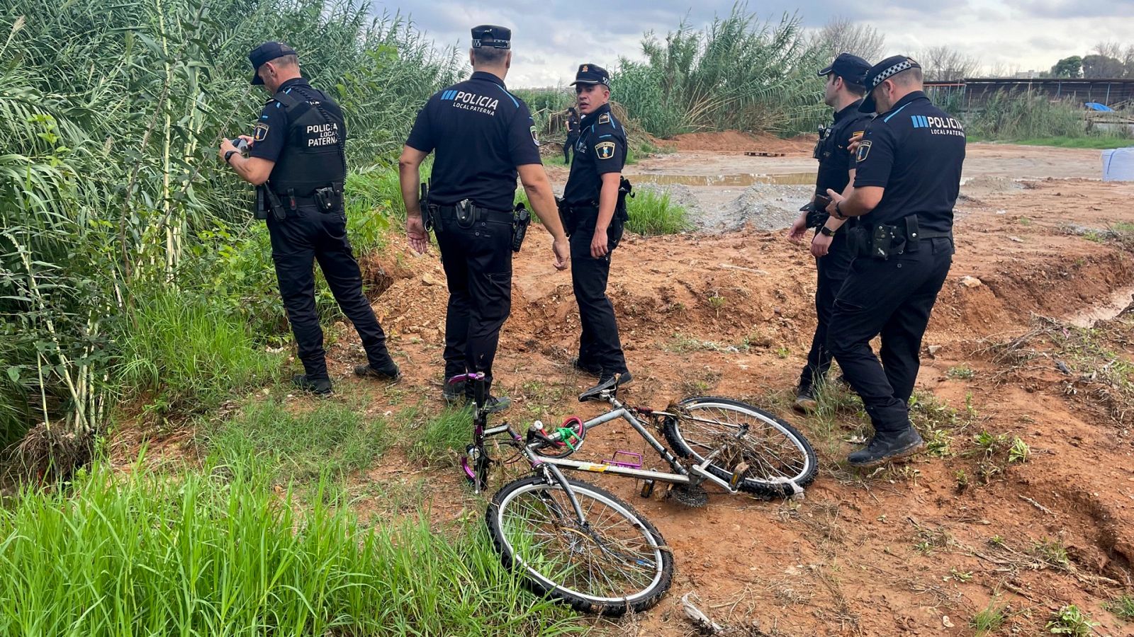La Policía Local de paterna junto a la bicicleta del hombre arrastrado por el agua en Paterna, Valencia