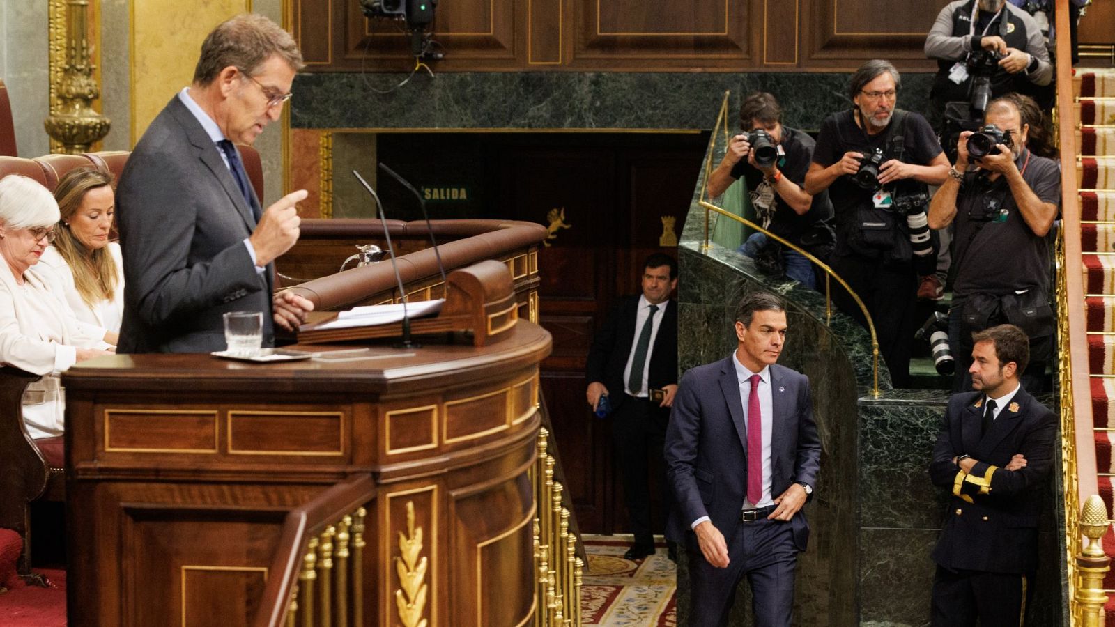 Alberto Núñez Feijóo interviene en el debate de investidura mientras pasa el presidente del Gobierno en funciones, Pedro Sánchez.