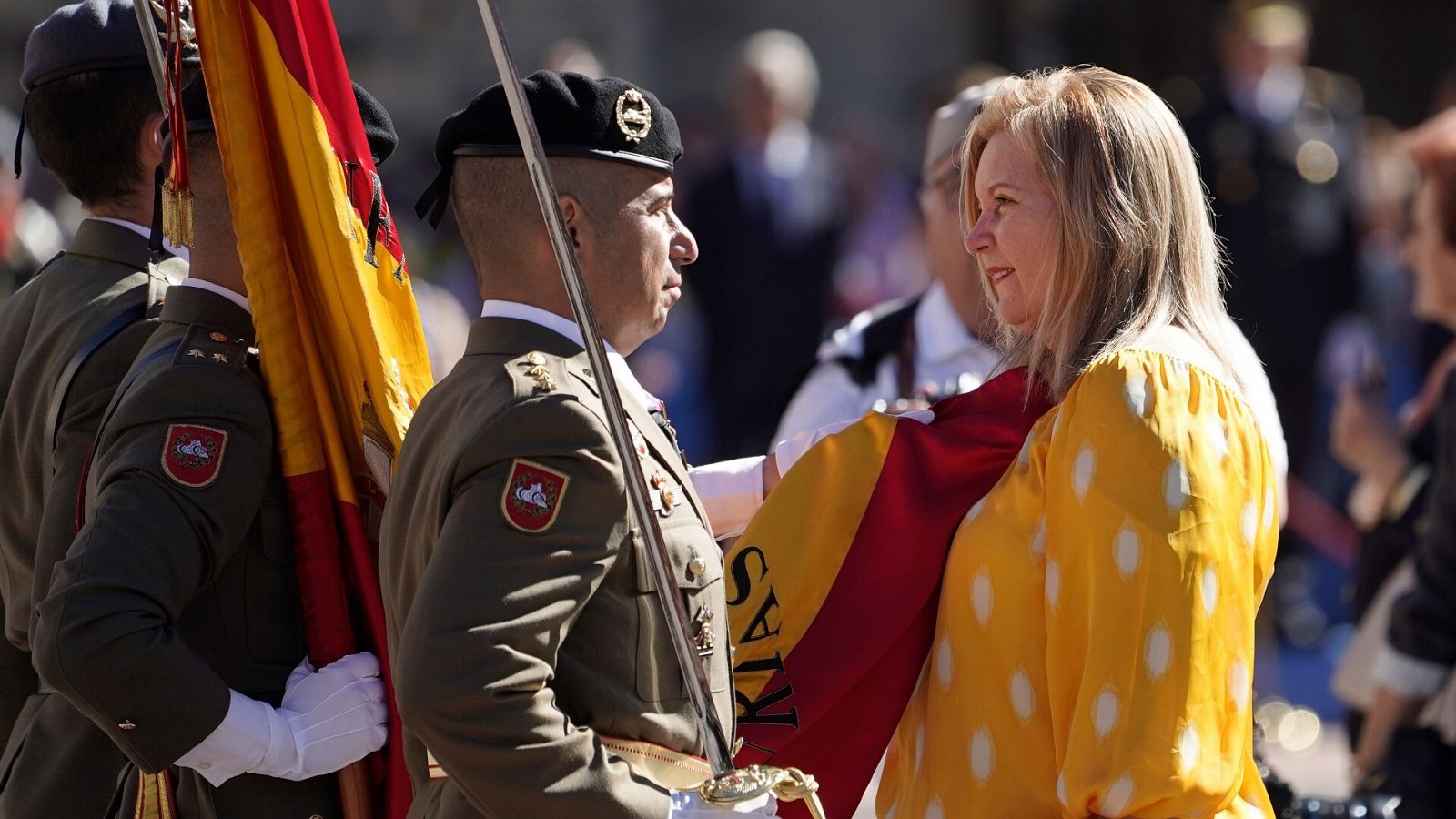 Una civil coloca la bandera en su pecho durante la Jura de Bandera en Oviedo.