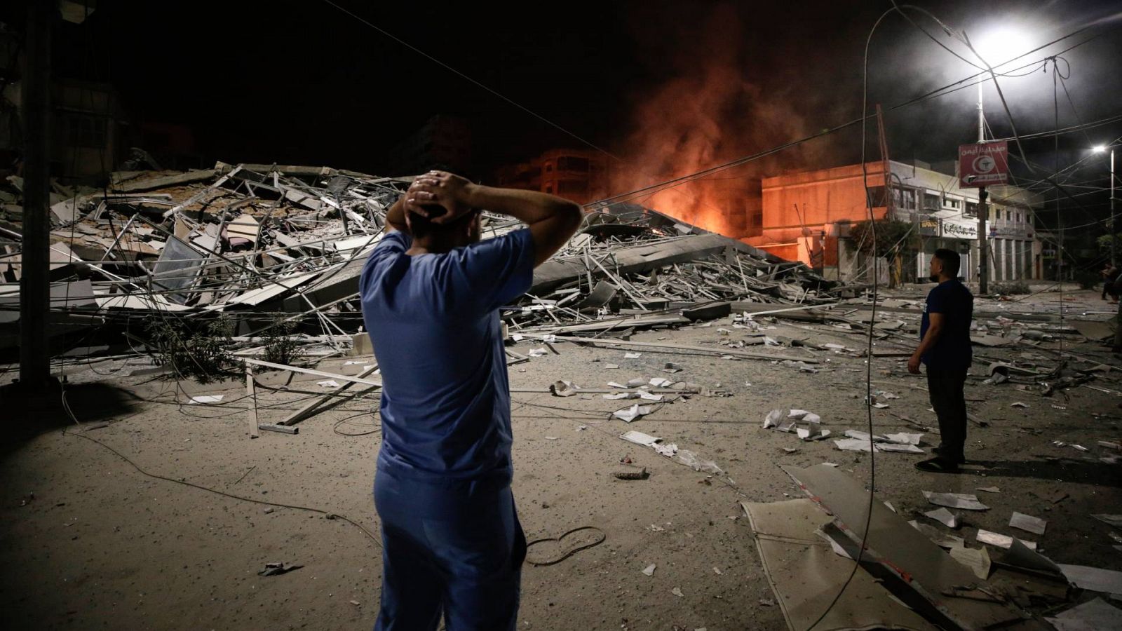 Dos hombres palestinos frente a los escombros que ha dejado un ataque en la Franja de Gaza