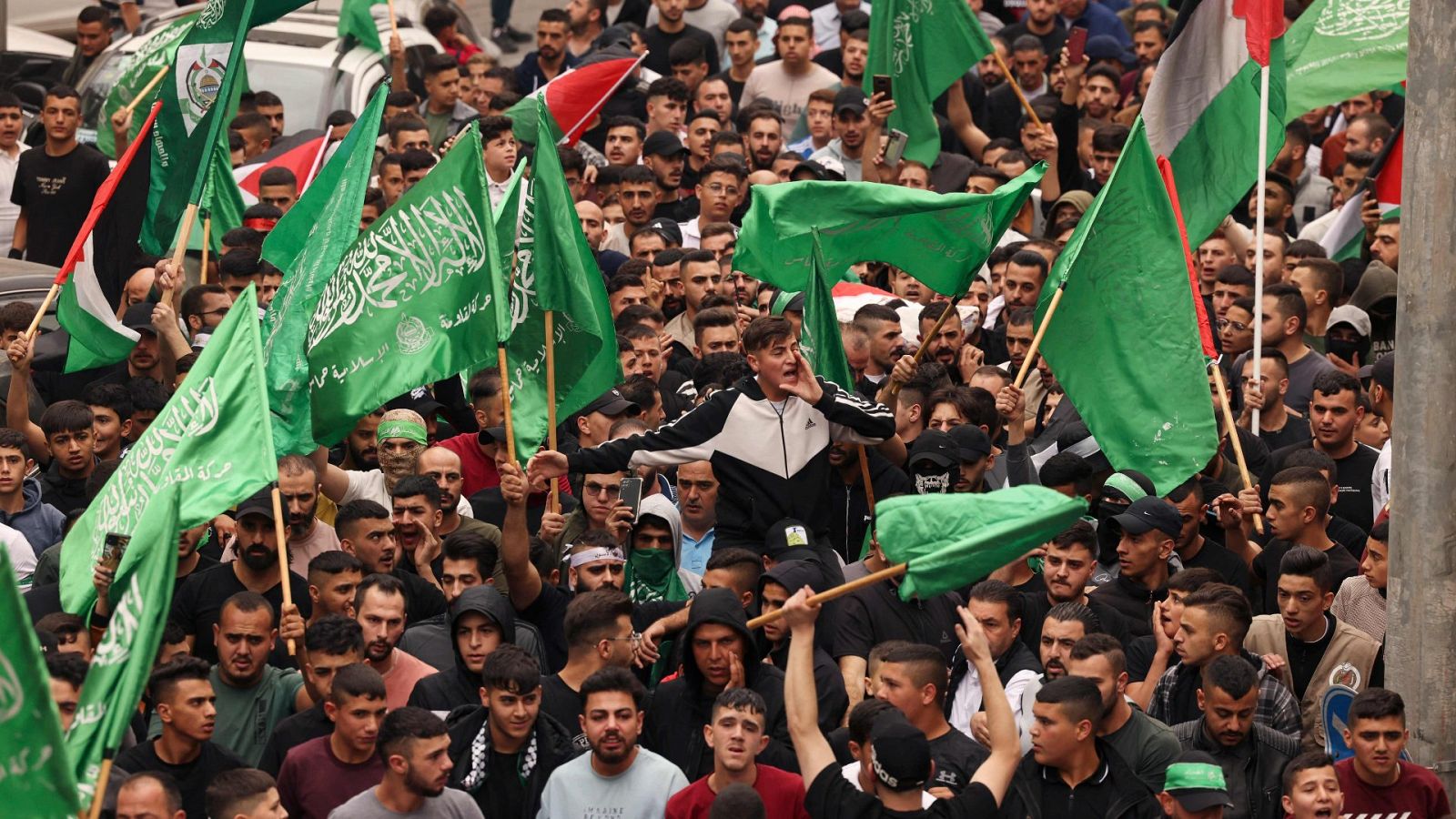 Palestinos ondeando banderas nacionales y de Hamás
