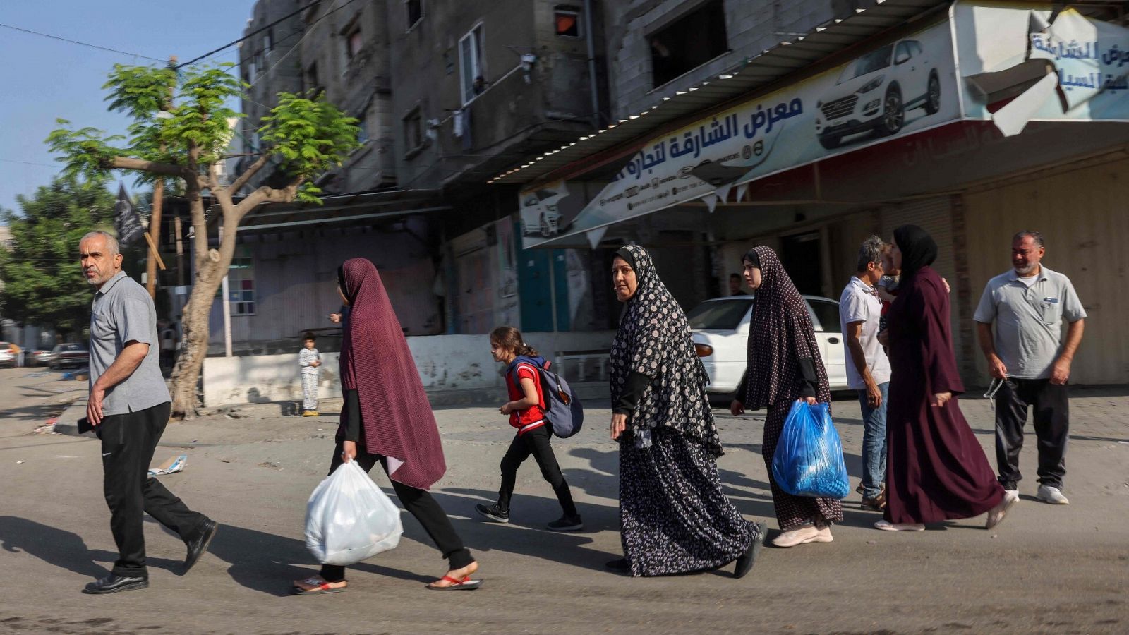 Palestinos cargados con sus pertenencias huyen a zonas más seguras en la ciudad de Gaza tras los ataques aéreos israelíes, el 13 de octubre de 2023.