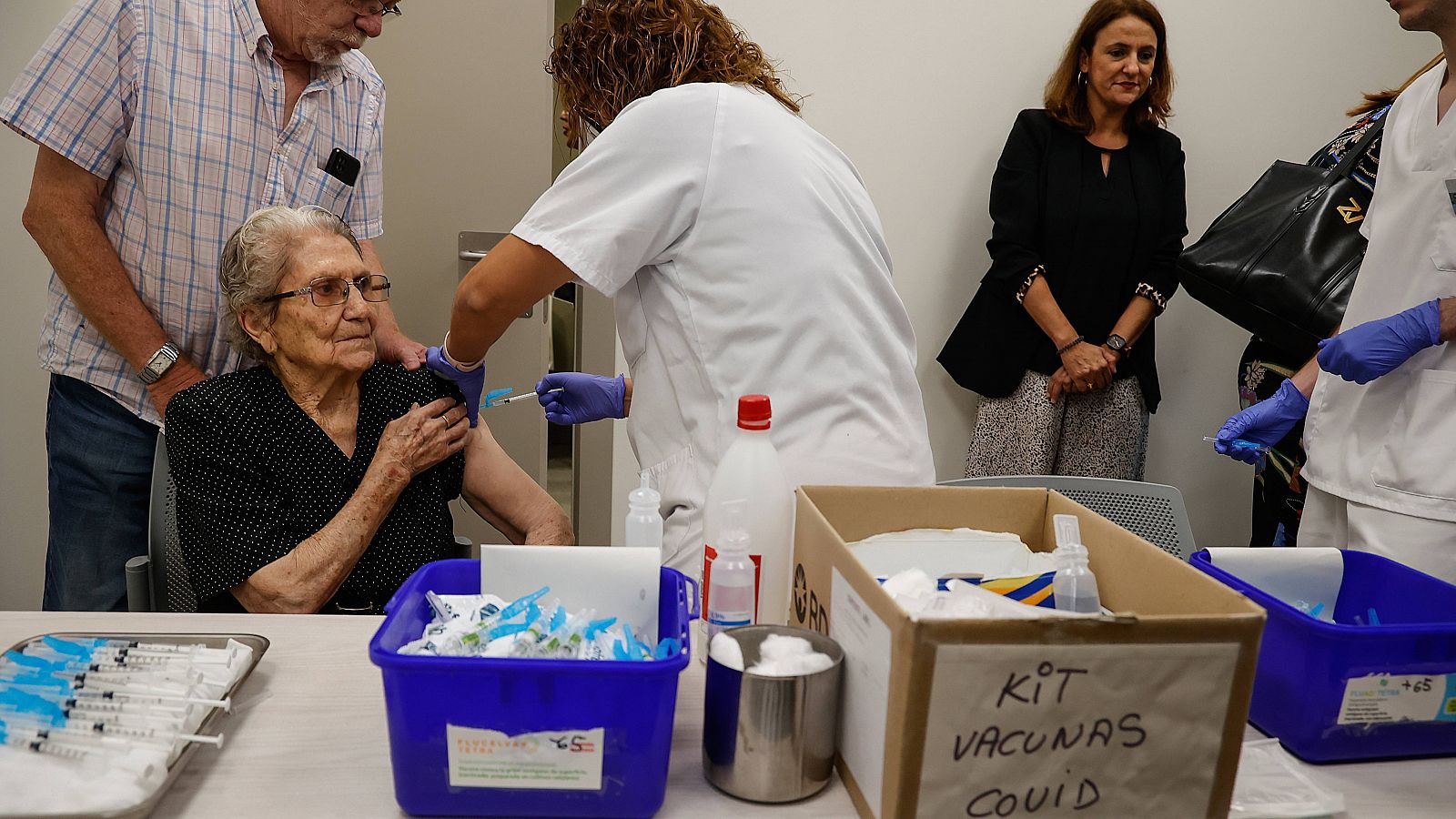 Vacunación contra la gripe y COVID: una mujer recibe las dos vacunas