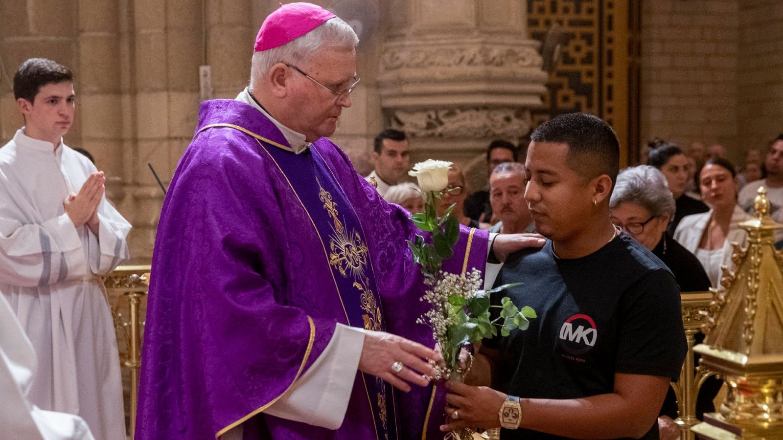 El obispo de la Diócesis de Cartagena entrega una flor a un familiar de los fallecidos