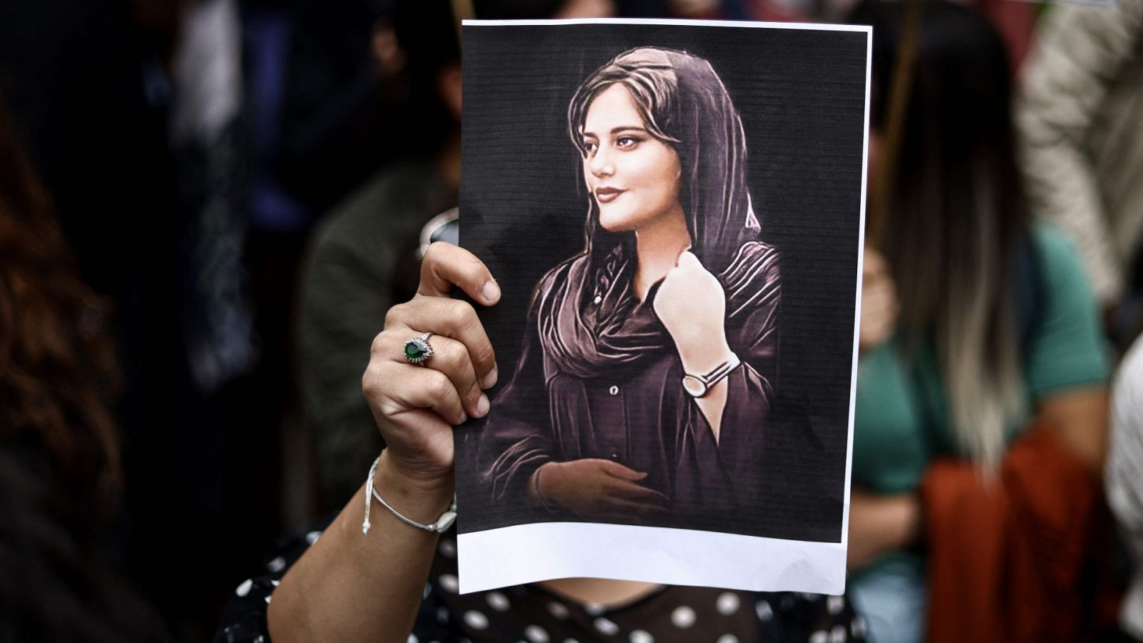 Una mujer sostiene un retrato de la joven Mahsa Amini, que murió bajo custodia policial en Irán.