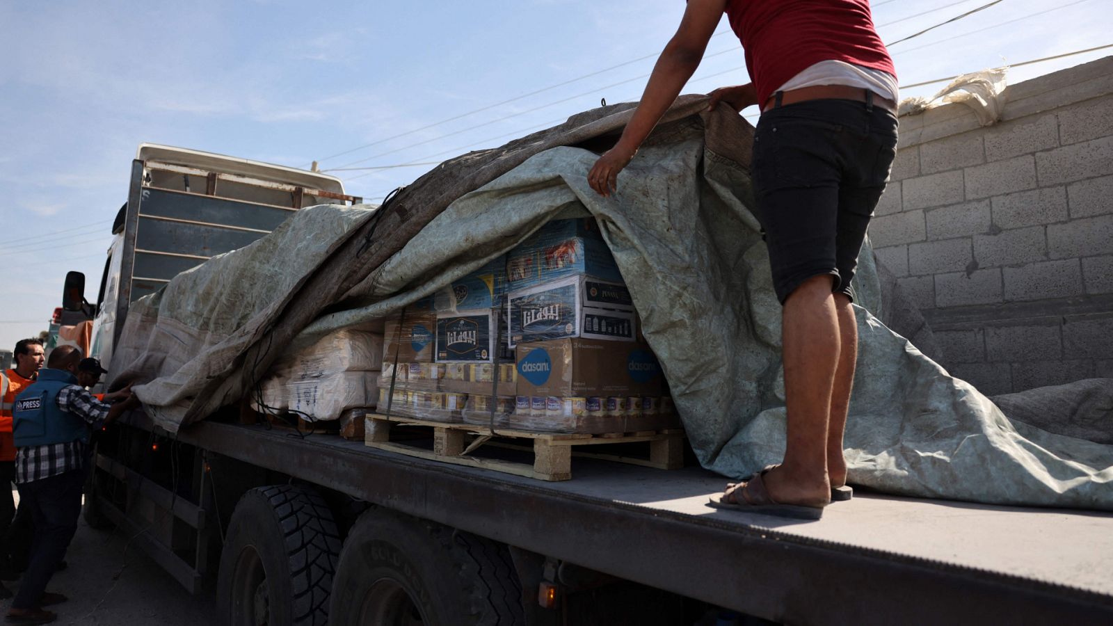 Un hombre organiza ayuda humanitaria para Gaza en el paso de Ráfah.