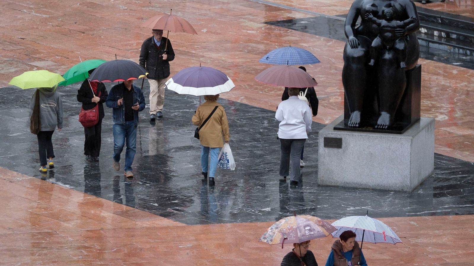 Viandantes con paraguas bajo la lluvia en Oviedo, Asturias