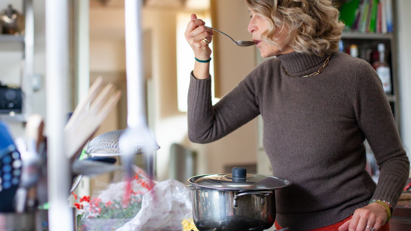 Una mujer prueba una sopa con una cuchara