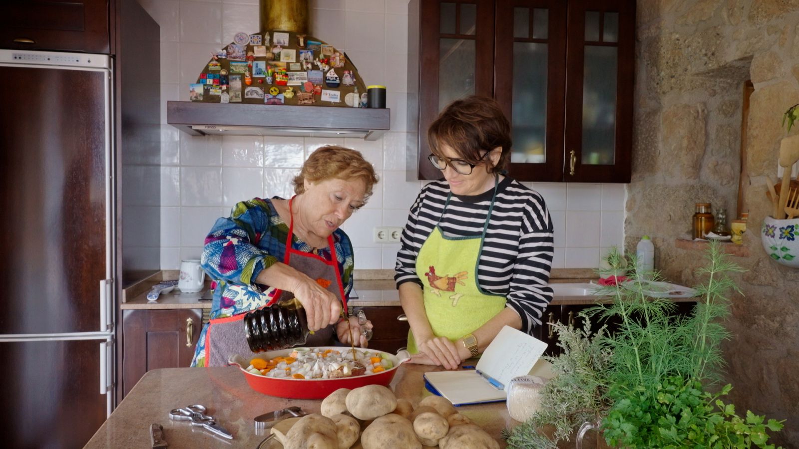 La Sílvia i la Teresa a la cuina, macerant el xai