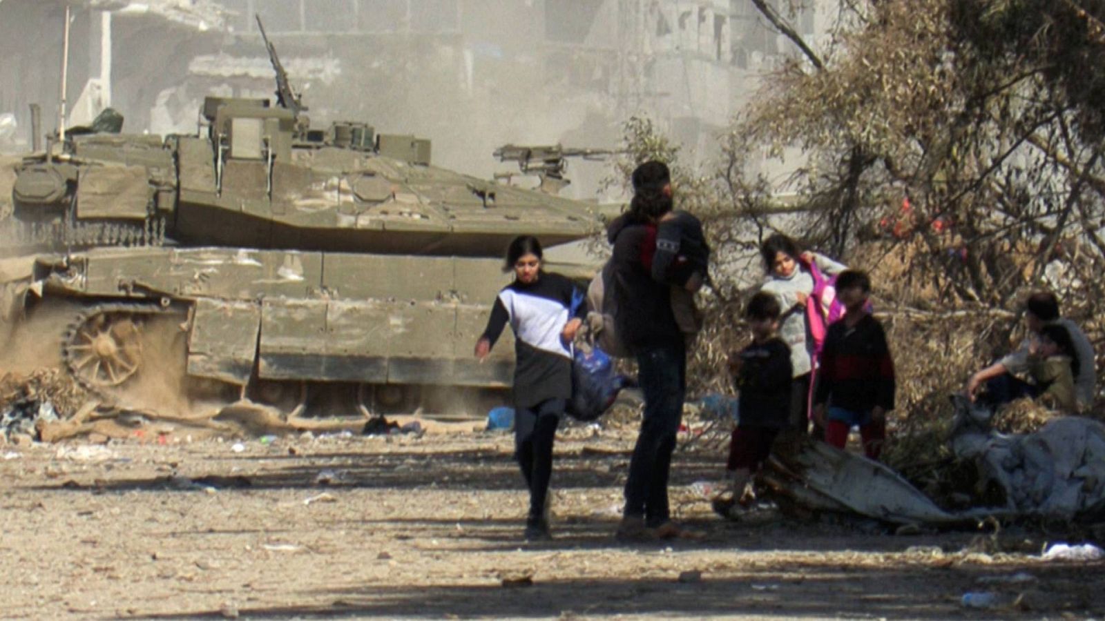Un grupo de personas delante de un tanque en la Franja de Gaza