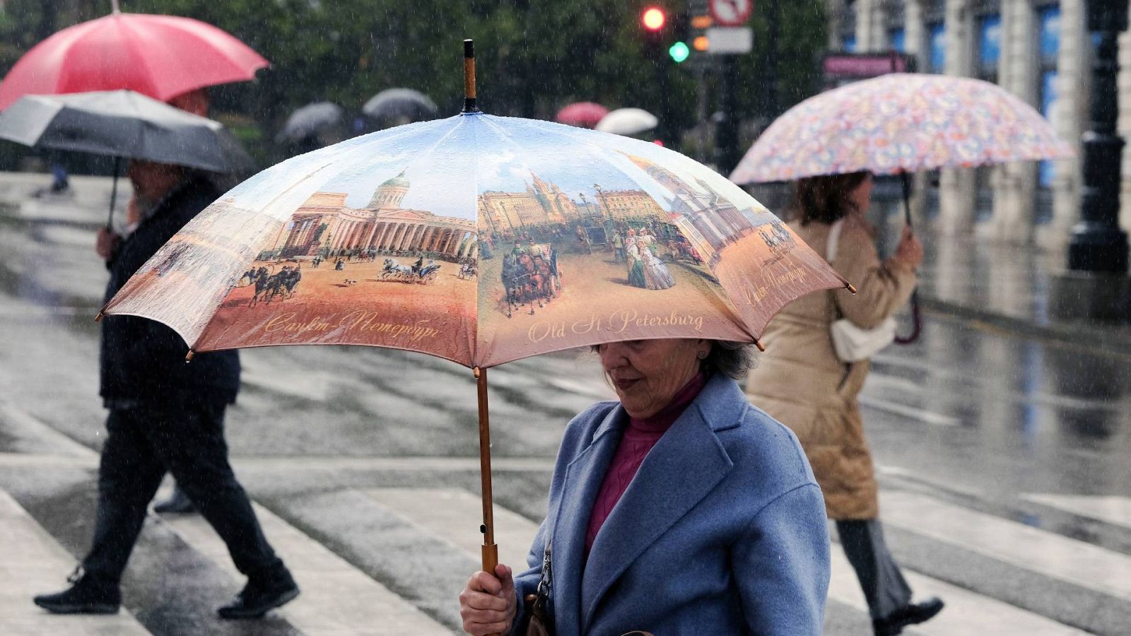 Una mujer se protege con un paraguas de la lluvia caída este lunes en Oviedo