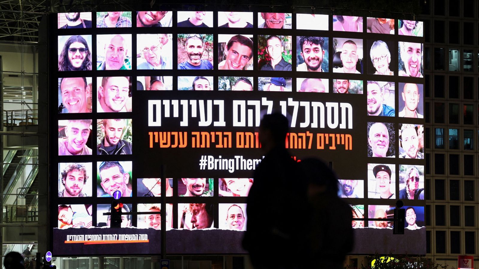 Una pantalla muestra fotografías de rehenes israelíes en Tel Aviv, Israel