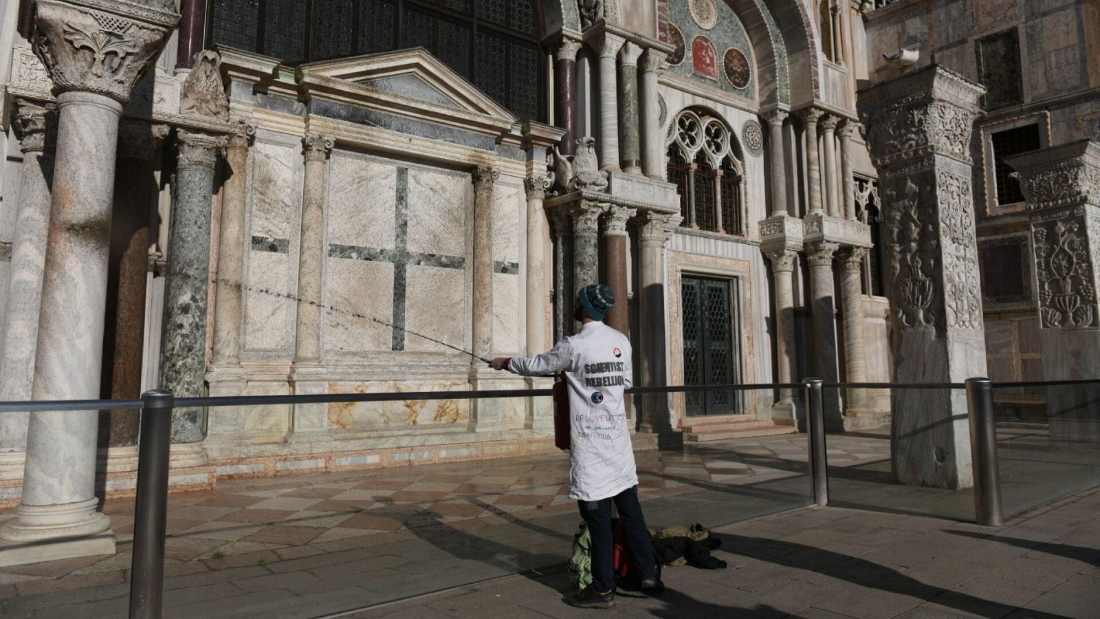 Un activista climático rocía barro en el exterior de la Basílica de San Marcos