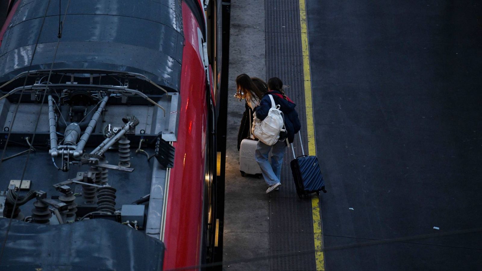 Dos viajeros entrando en un tren en la estación de Atocha