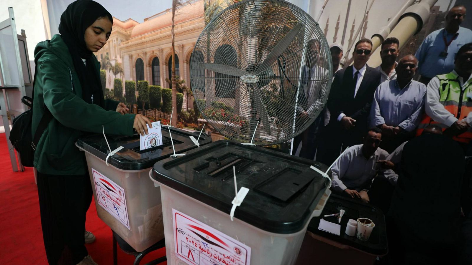 Una mujer deposita su voto en una mesa electoral en el Cairo