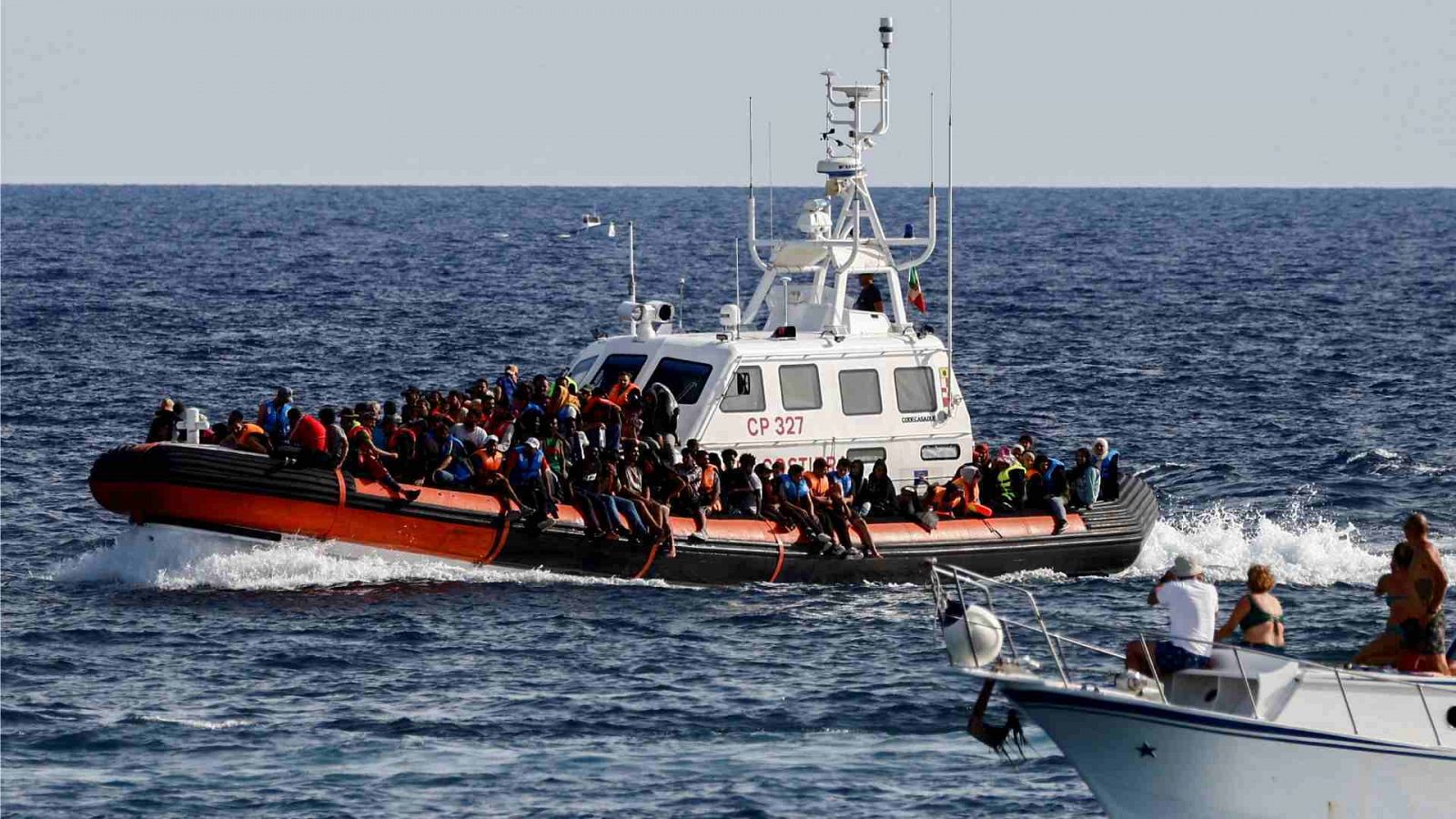 Un buque de la Guardia Costera italiana transporta migrantes rescatados en el mar, en la isla siciliana de Lampedusa, Italia.