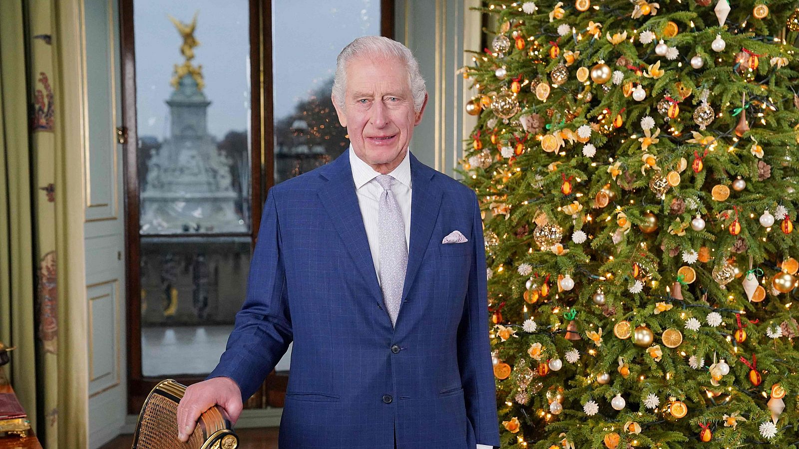 El rey Carlos III de Inglaterra posa durante la grabación de su mensaje navideño en el Palacio de Buckingham