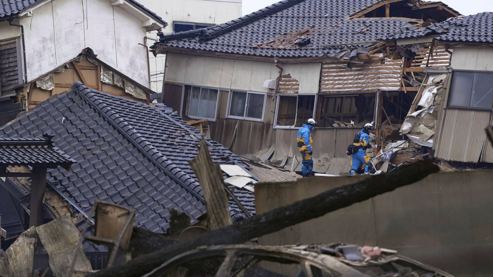 Dos policías buscan supervivientes entre las casas dañadas por el terremoto en Wajima, Ishikawa