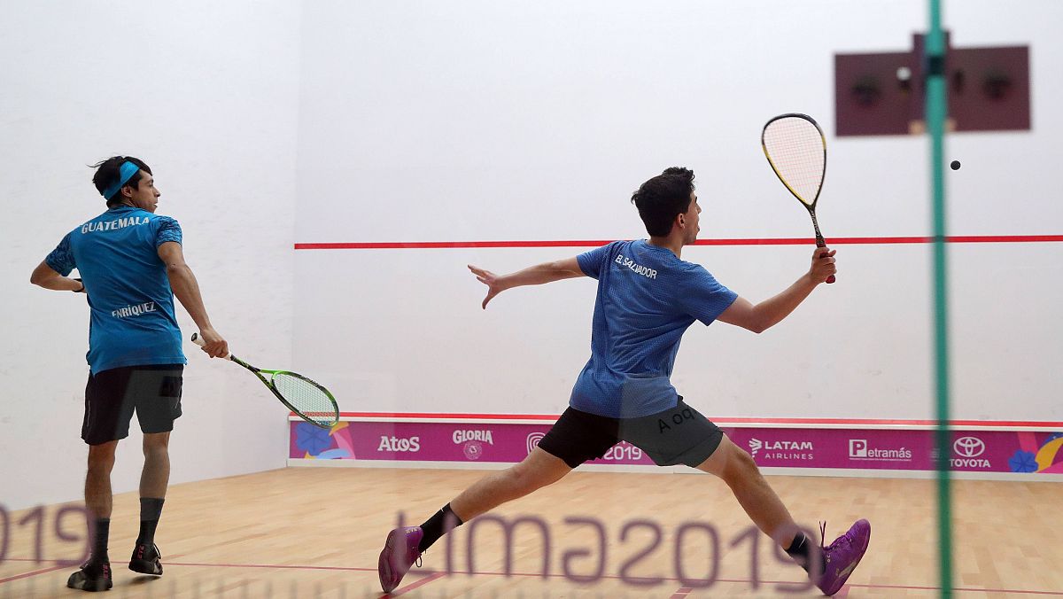 Dos jugadores de squash en una pista cubierta
