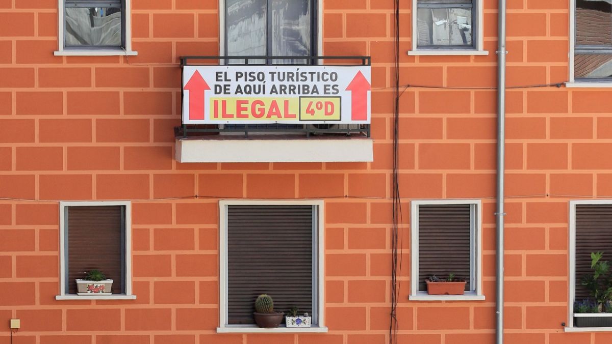 Cartel en la fachada de un edificio con pisos turísticos