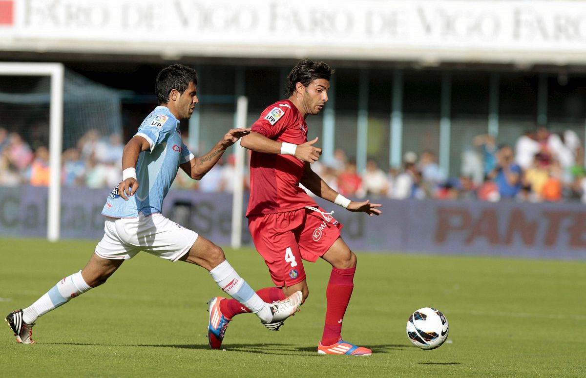 El defensa argentino del Celta, Gustavo Cabral, presiona al defensa del Getafe, Miguel Torres.