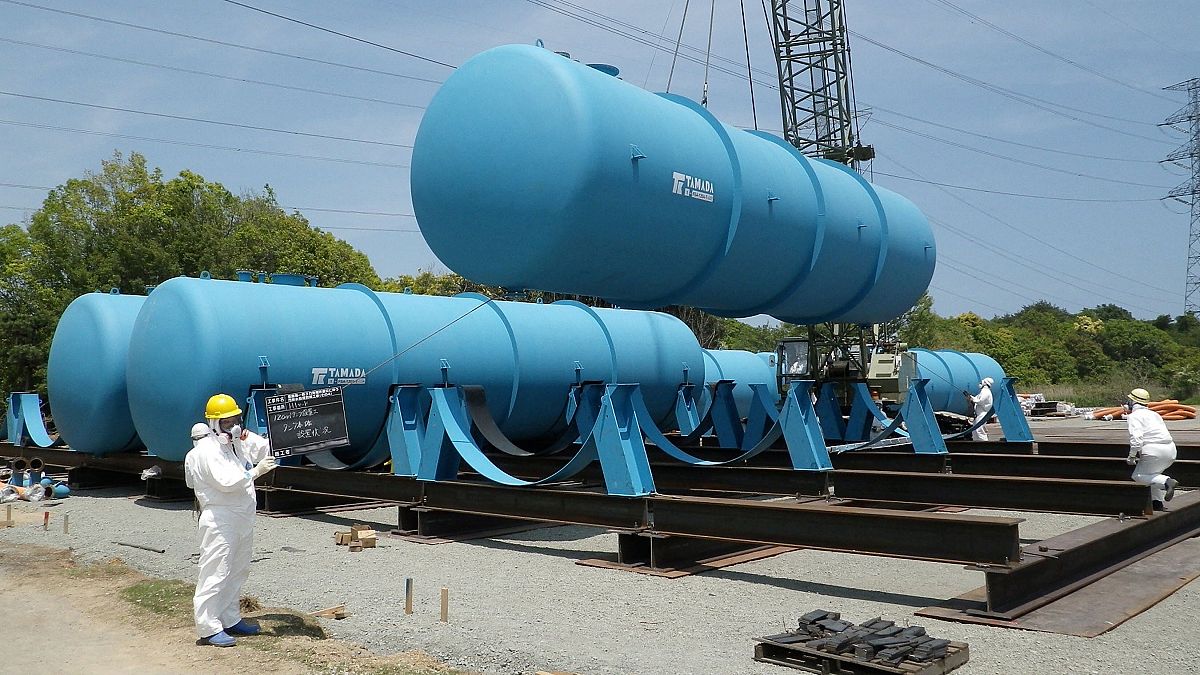 Trabajadores instalando grandes tanques para almacenar agua contaminada radiactiva en la planta de energía nuclear Fukushima Dai-ichi de TEPCO